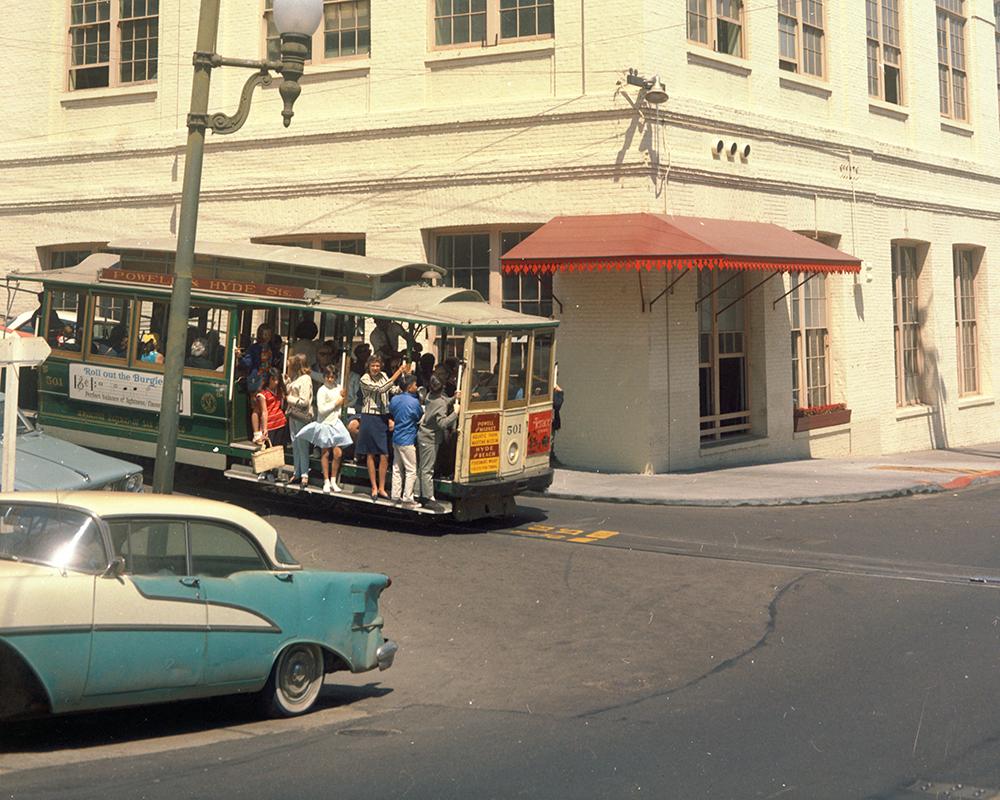 A cable car passes the Cable Car Barn at Washington Mason after completed restoration of the building in July 1965.