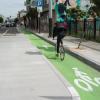 8th Street after: bicyclist riding in a bikeway protected by a loading island.