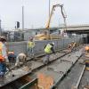 Workers traverse the site carefully during the last of the tunnel portal invert concrete pour, completing the foundation and roa