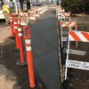 Concrete path, still wet, with construction barriers surrounding