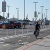 A bicyclist in a two-way protected bikeway buffered with plastic delineators