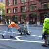 Two employees with equipment painting the road