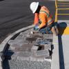 Image of worker installing pavers at a new median refuge at Geary and Steiner