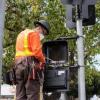 Photo of A crew member programming a pedestrian signal on a recently-installed traffic signal on Van Ness.