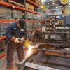 Worker welding a metal cable car frame