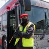 Operator standing in front of bus with open doors