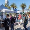 Muni Heritage attendees looking at information board at an event booth