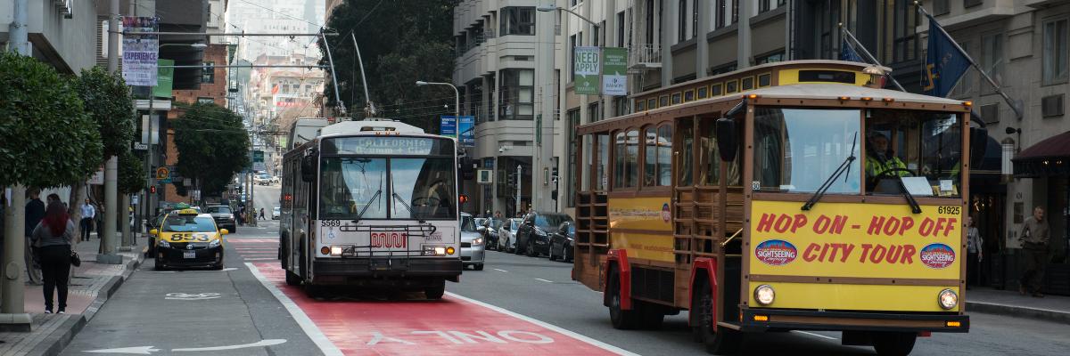 Hop-on hop-off tour bus and Muni trolleybus on Clay Street in the Financial District