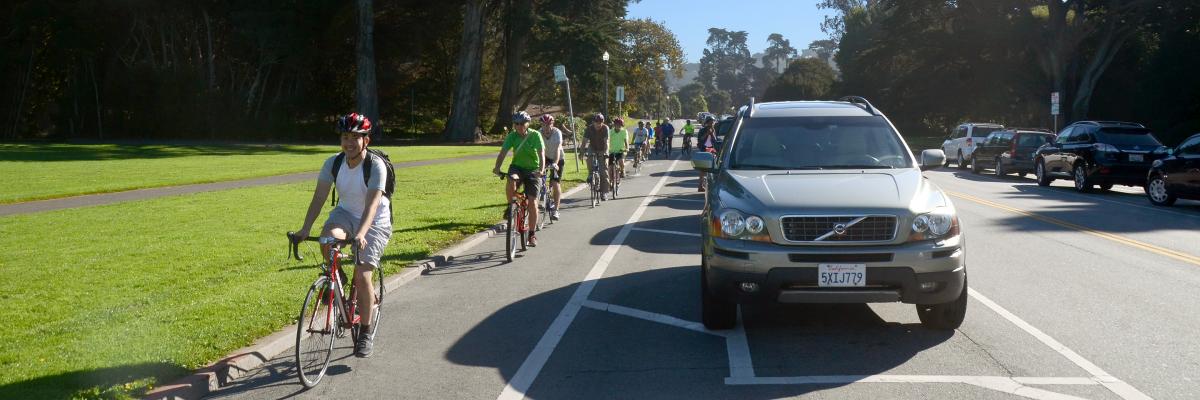 Photo of people bicycling on the parking-protected bikeway on JFK Drive.
