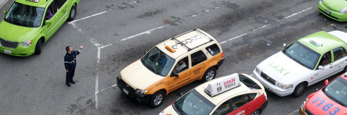 Taxi cabs parked in a row with service person