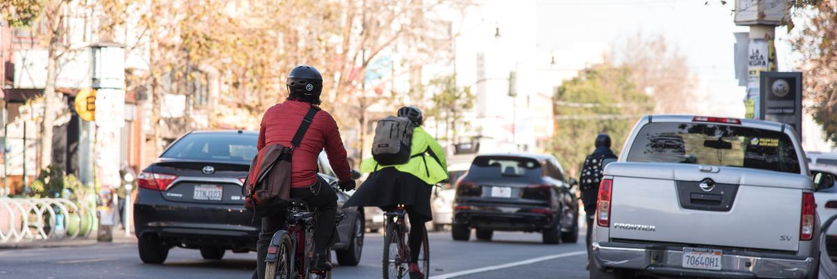 People biking and driving on Valencia St