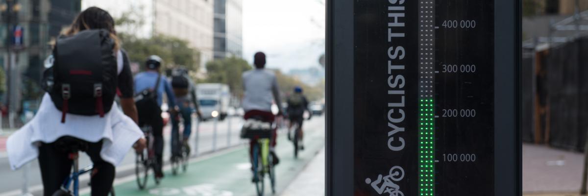 People biking past Market St bike totem