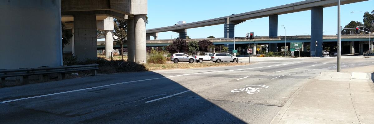 Alemany Boulevard eastbound approaching the US 101 N on-ramp, with a shared bike route marking in the rightmost of three lanes.