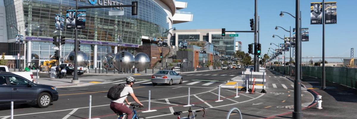 A bicyclist in a two-way protected bikeway buffered with plastic delineators