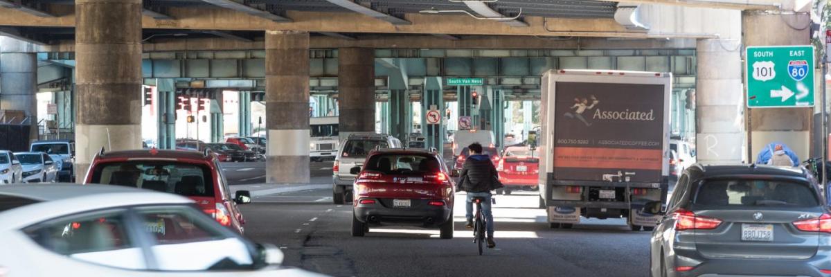 A bicyclist rides in mixed traffic on 13th Street