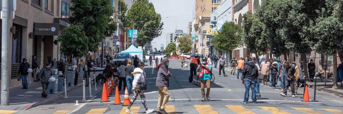 People walking across a crosswalk in the Tenderloin