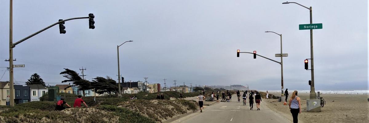 Car-free Great Highway at Noriega Street looking south with pedestrians and bicyclists next to Ocean Beach