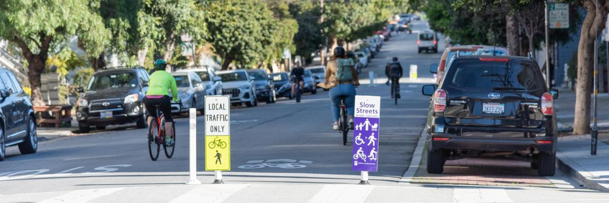 people biking on Page Slow Street; the slow streets signage that says Local Traffic Only is visible on the street
