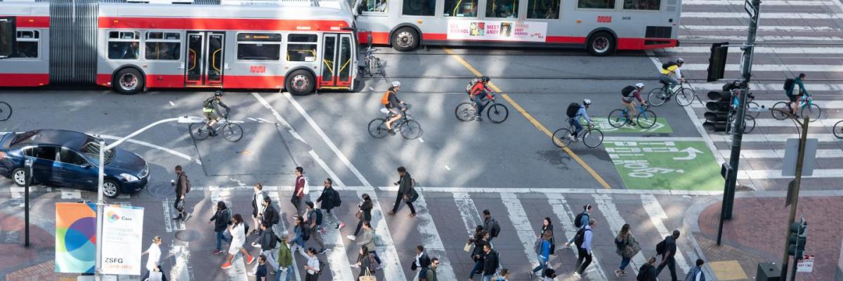 Overhead view of crosswalk at Market Street and 10th Street with two buses and people riding bicycles and walking