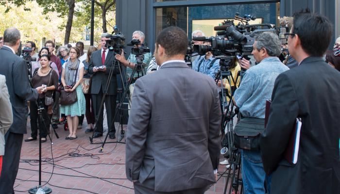 group of news camera people at press event on market street