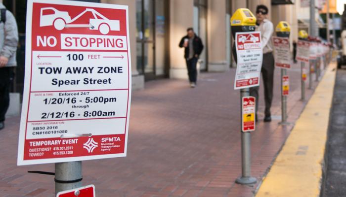 row of parking meters with no stopping temporary event signs