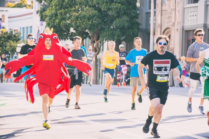 Men running in the Bay to Breakers race, including one wearing a lobster costume.