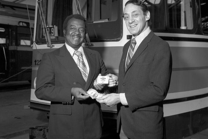 Black and white photo of Curtis Green and Harvey Milk standing in front of a streetcar.