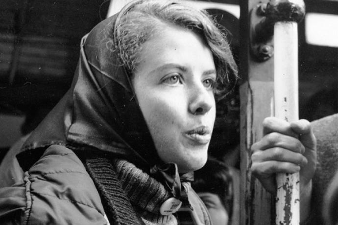 Mona Hutchins holding a pole while standing on a crowded cable car.