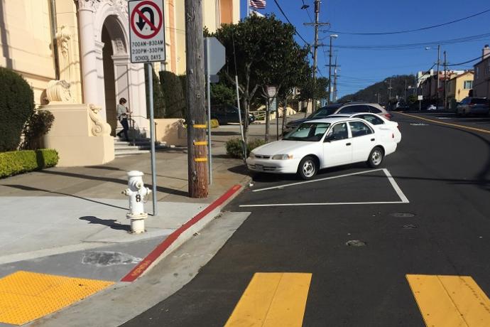 A corner on Vicente Street with existing “front-in” angled parking and “daylighting.”