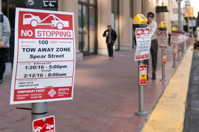 row of parking meters with no stopping temporary event signs