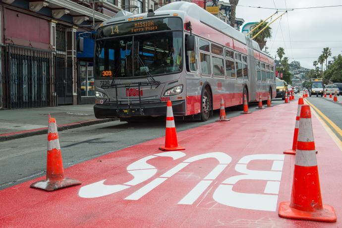 bus driving by red transit lane work on mission street