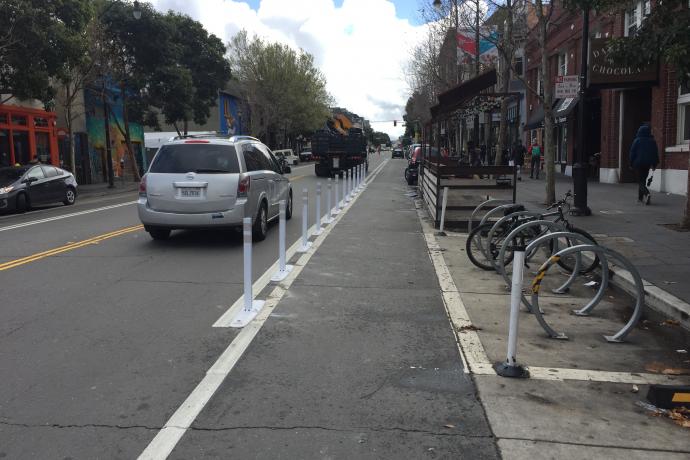 New paint and flext post on Valencia Street in front of a parklet and bike corral