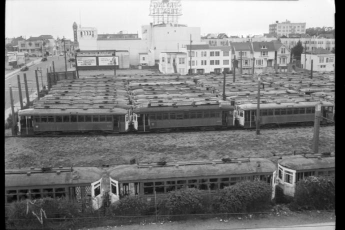 derelict streetcars sit in a large empty lot