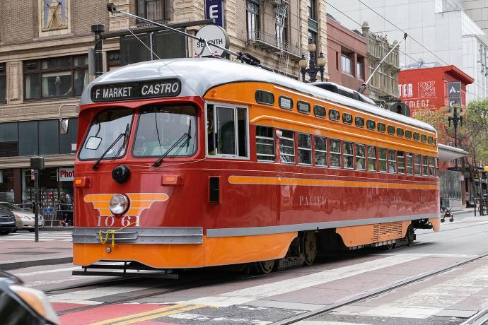 red and orange streetcar running on F Line along Market Street