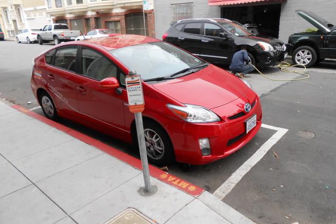 A shared vehicle parked at a permitted car share only curbside parking space.