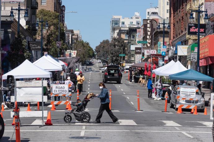 Photo of a street closed in the Tenderloin during summer 2021 with vendors and pedestrians