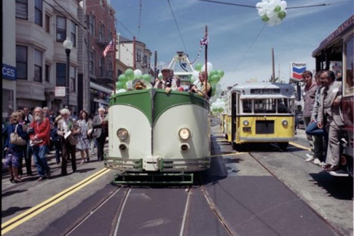 Photo of the Boat Tram on parade at the 1983 Trolley Festival with parade goers waving in excitement.