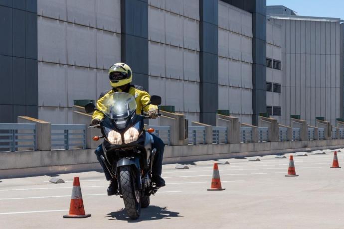 Image of motorcyclist weaving through cones during a motorcycle safety class.