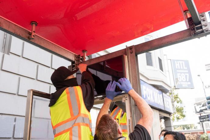 Crews working on a screen display at a bus stop