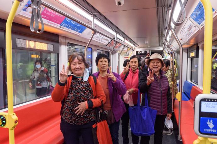 Image of Muni Metro riders smiling at the camera