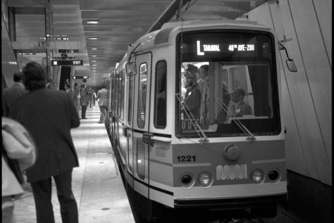 black adn whtie photo of Muni LRV signed for L Taraval Line at platform in Embarcadero Station