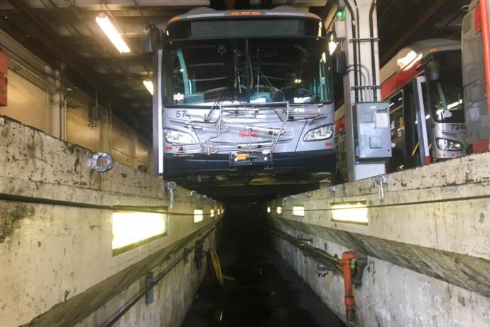 alt="A low-angle view of one of the trenches used to work on the undercarriages of the trolley buses at Potrero Yard. Fall, 2021
