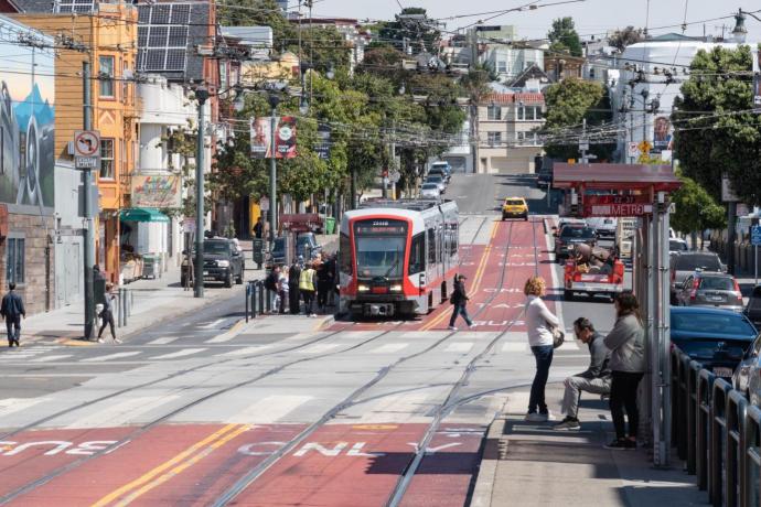 J Church using red transit lanes and picking up passengers on a boarding island on Church at Market Street. 