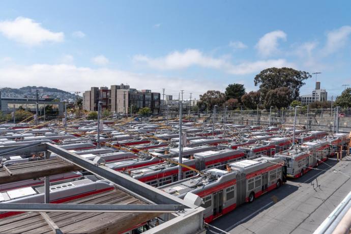 a high-angel view of a crowded bus yard, packed with trolley buses