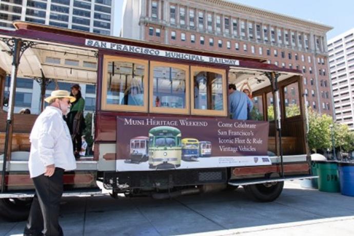 A San Francisco Cable Car with a banner that says Muni Heritage Weekend on the side.