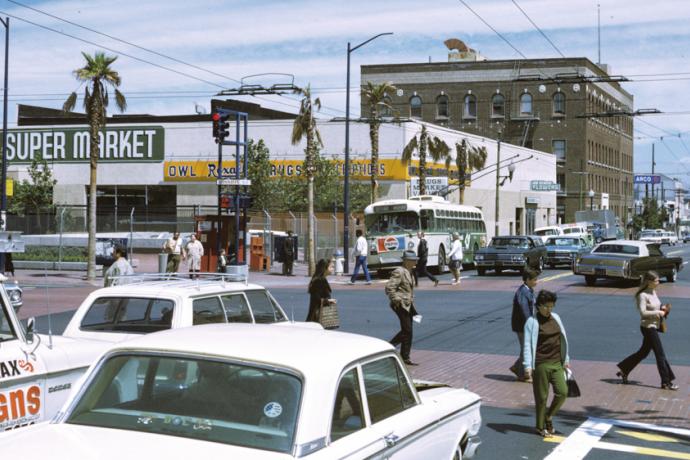 1970s photo of people crossing street with cars and buses on Mission and 16th streets