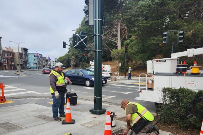 Electricians wiring recently installed traffic signals at Kezar Dr and Lincoln Way
