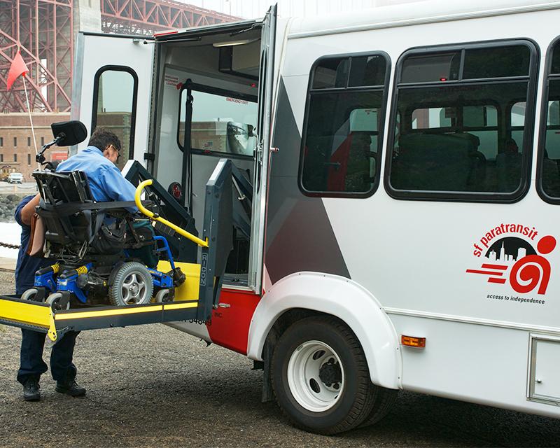 person in wheelchair riding lift into side of accessible van
