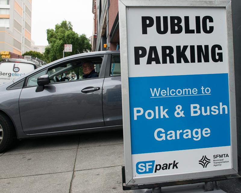 car exiting parking garage driveway with sign reading "Public Parking"
