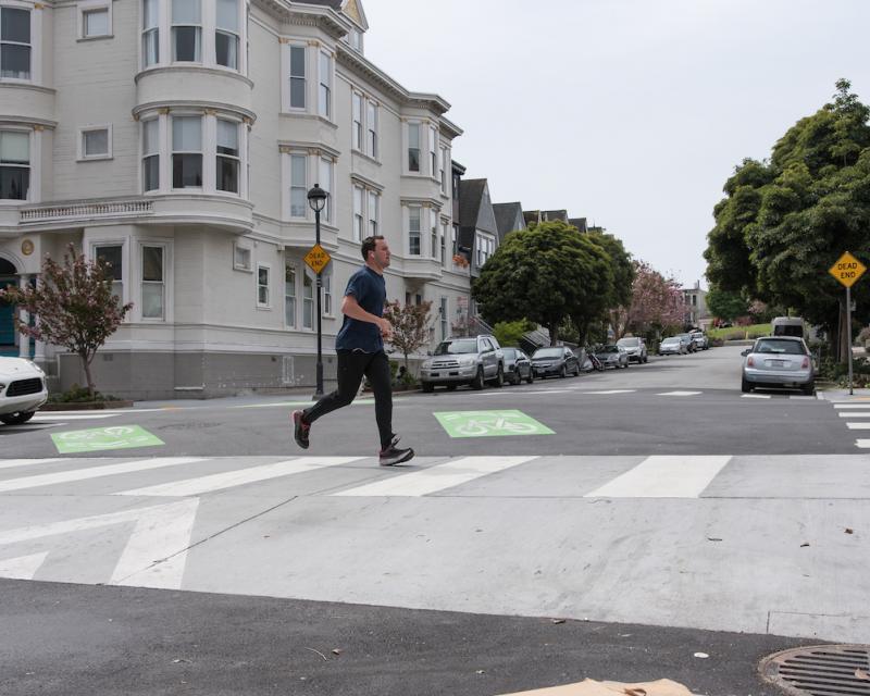 Person walking on a need raised crosswalk along the Wiggle